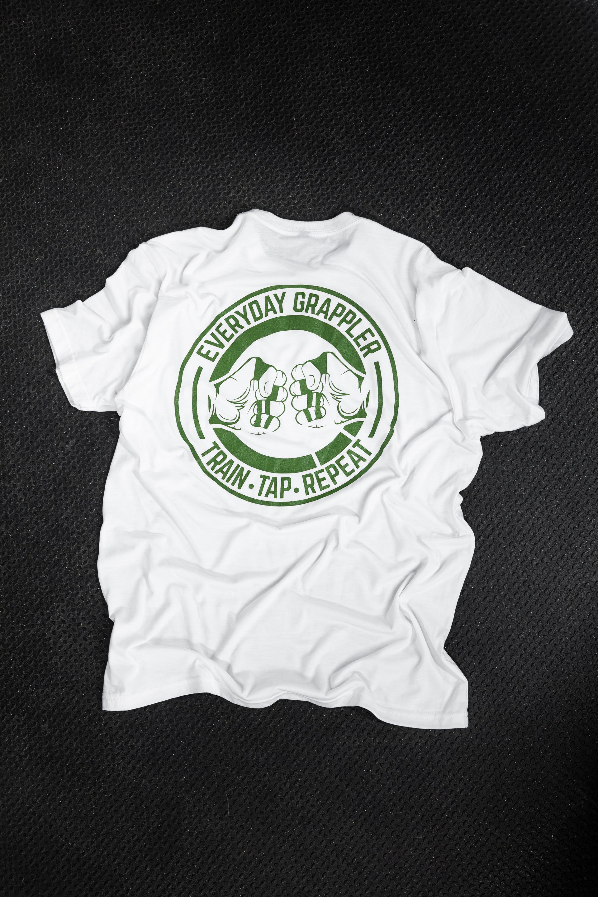 Back of the white Everyday Grappler BJJ tee with the green circular Train Tap Repeat fist-bump logo