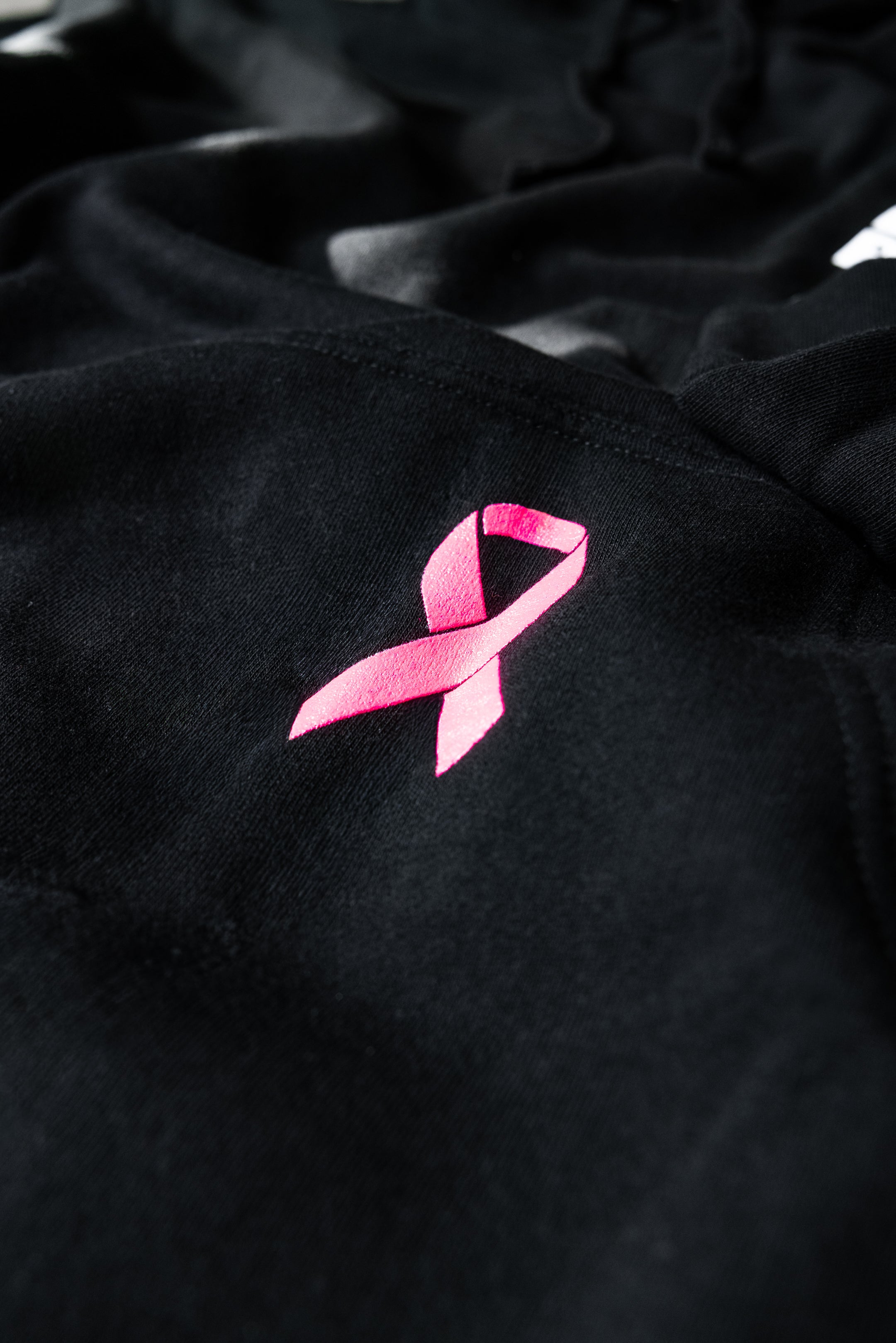 Pink breast cancer awareness ribbon embroidery detail on SBR Choking Out Cancer Hoodie pocket