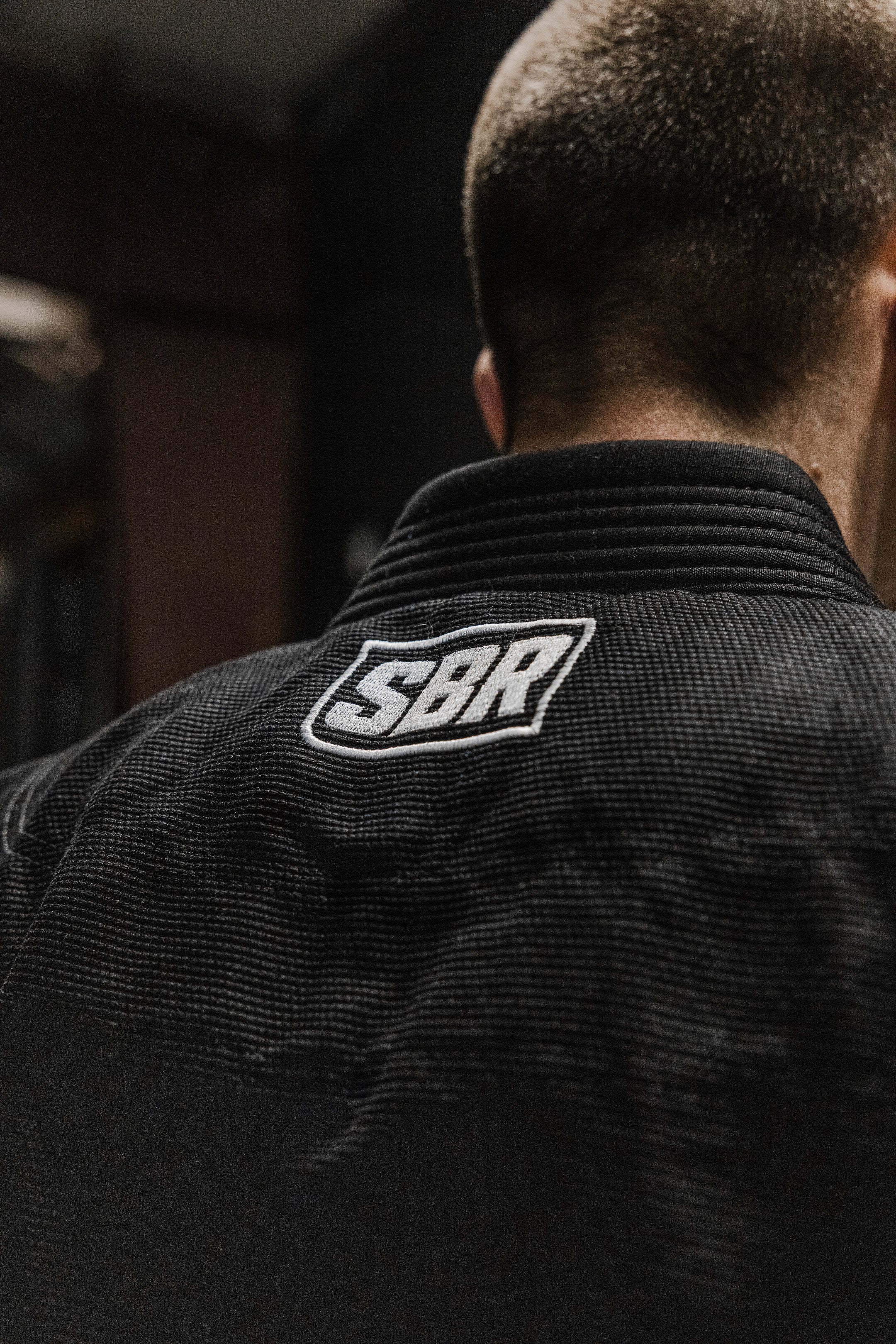 Back collar SBR box logo patch on black SBR Comp Lite BJJ Gi worn by athlete