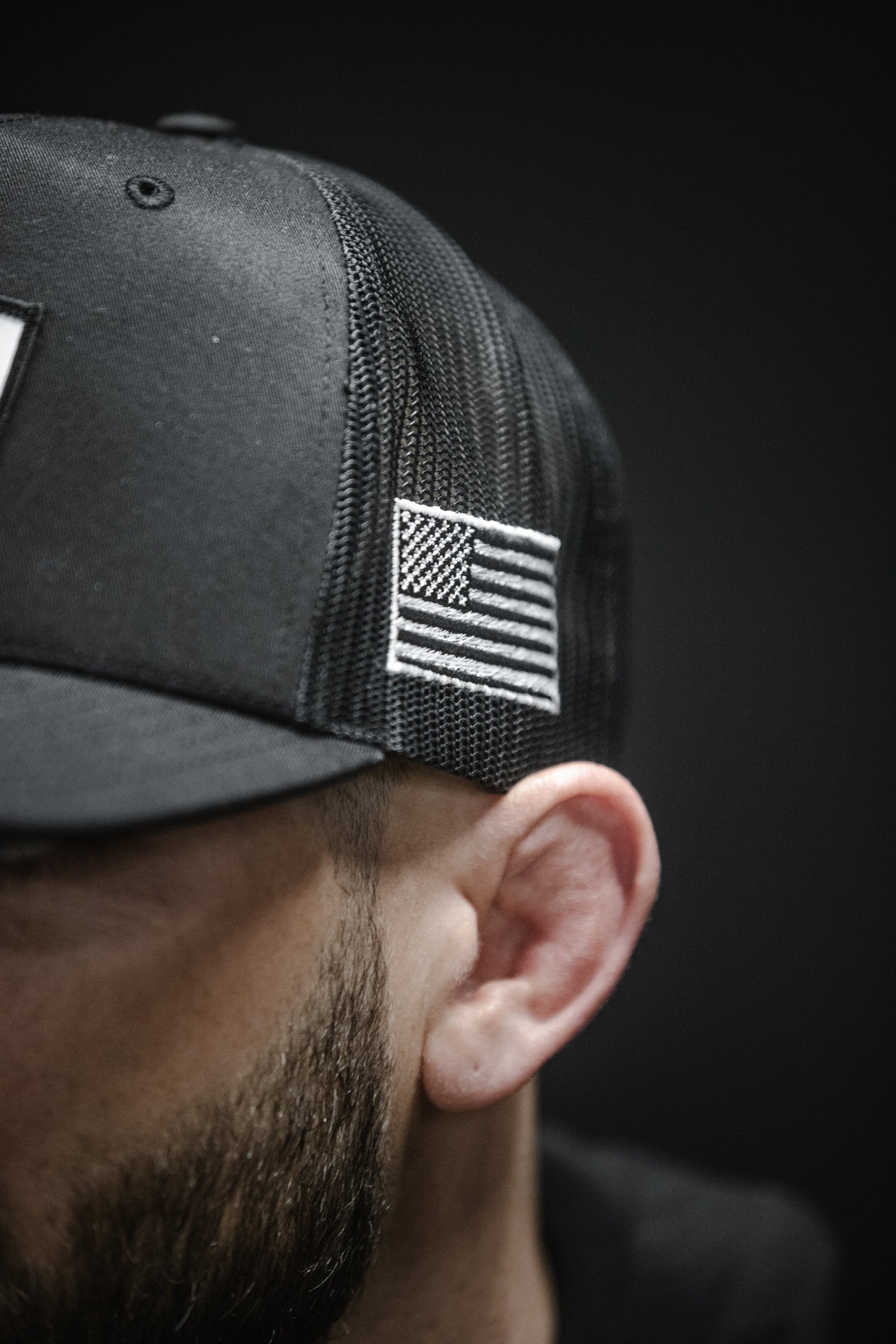 Back mesh and American flag patch detail on SBR Jiu Jitsu Trucker Hat worn by athlete