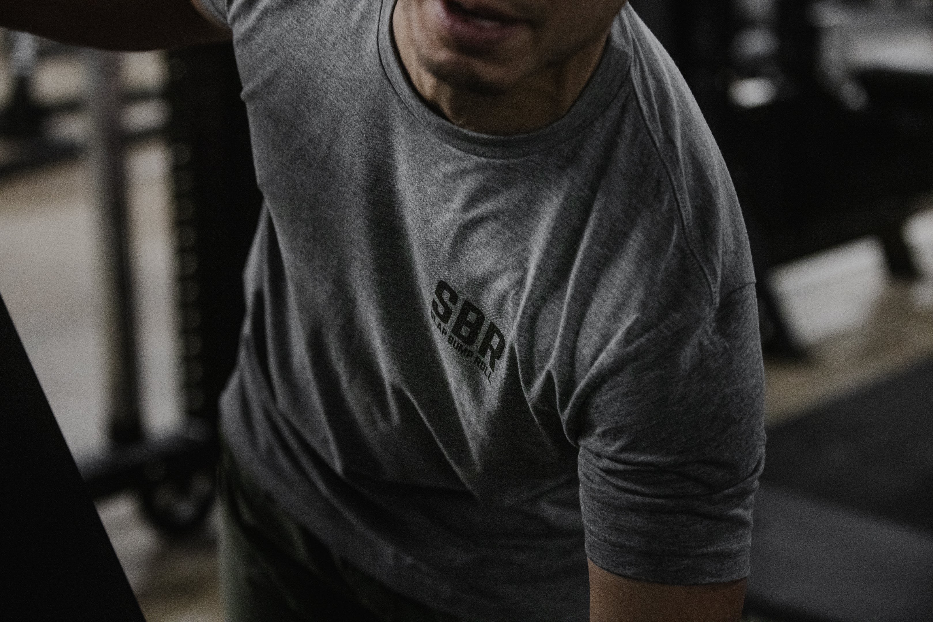 Athlete training in the heather grey Slap Bump Roll tee showing the SBR chest wordmark
